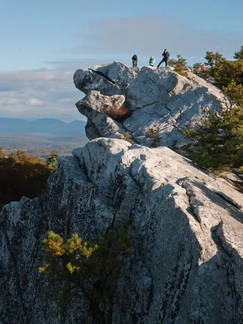 Hikers standing on a rock outcrop above the valley